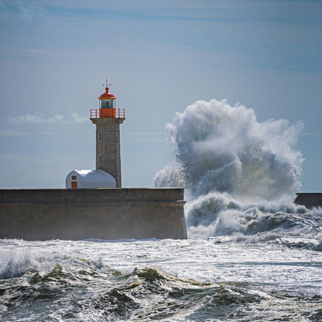 Lighthouse by the sea with crashing waves