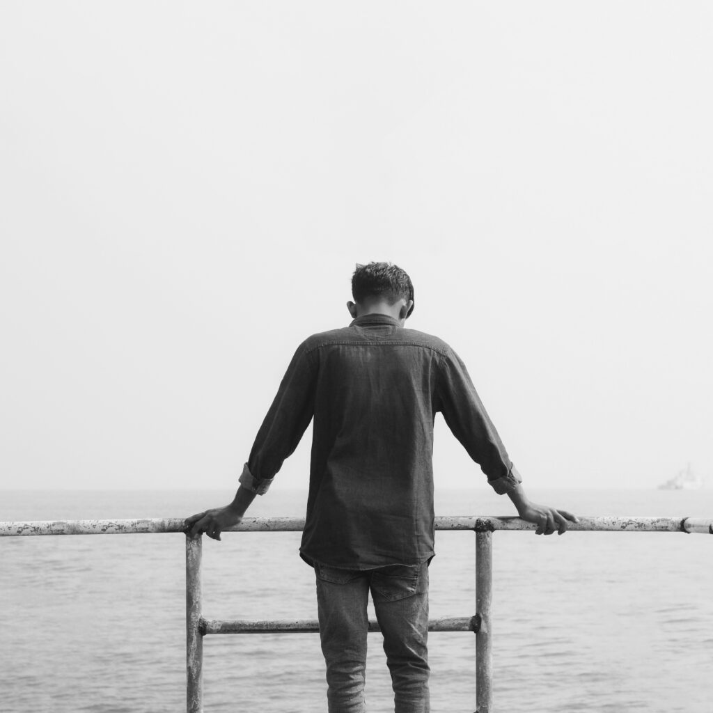 Person standing by ocean railing.