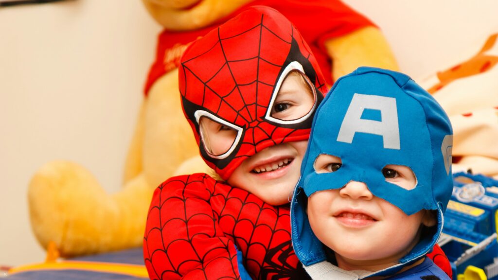 Kids in Spiderman and Captain America costumes smiling