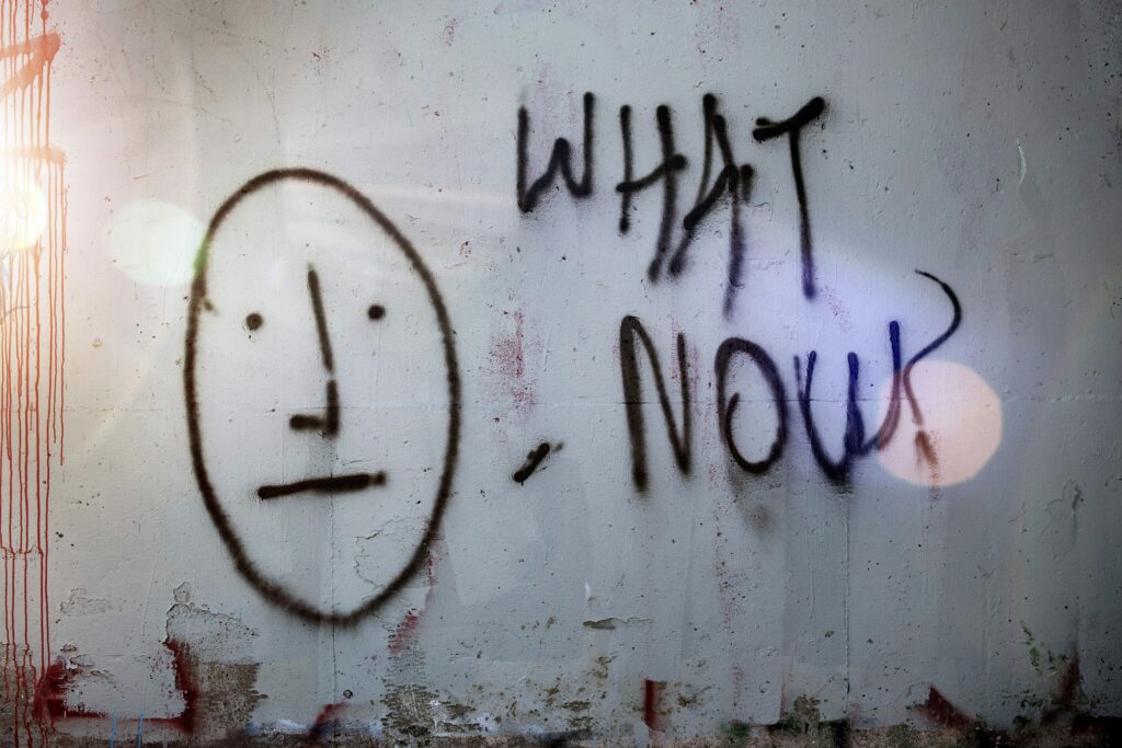 Graffiti face with 'What Now?' text