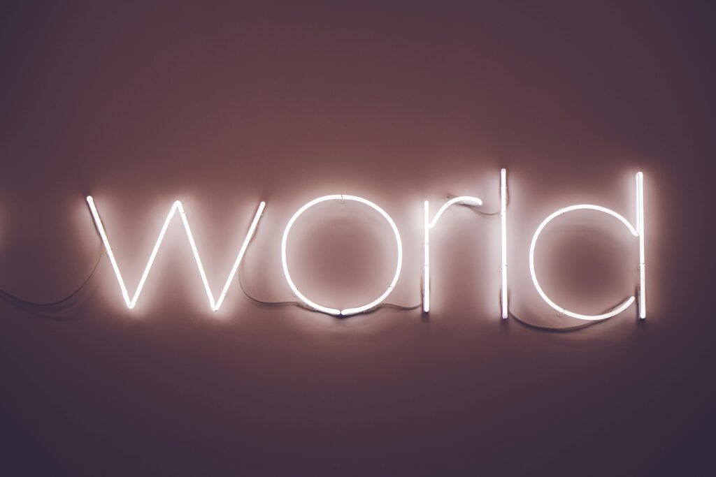 Neon sign spelling 'world' on dark background.