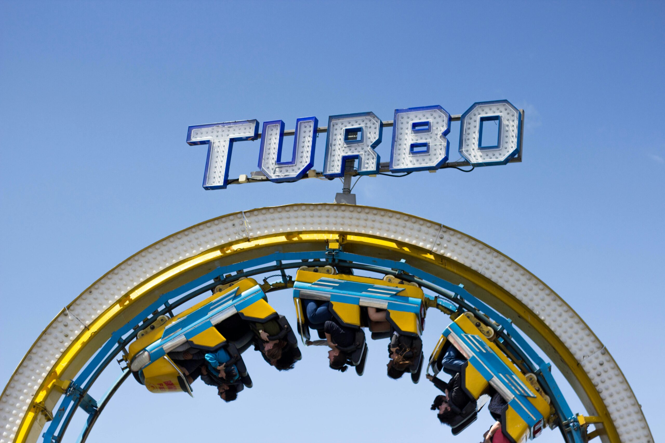 Roller coaster loop under Turbo sign.