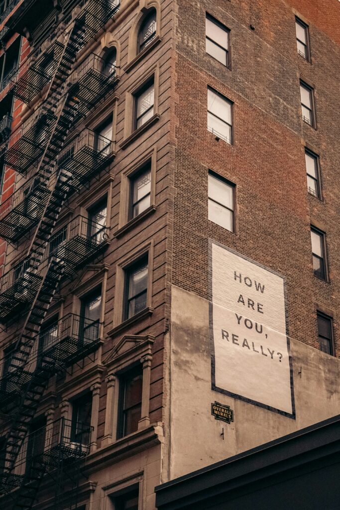 Sign on urban building: 'How are you, really?'