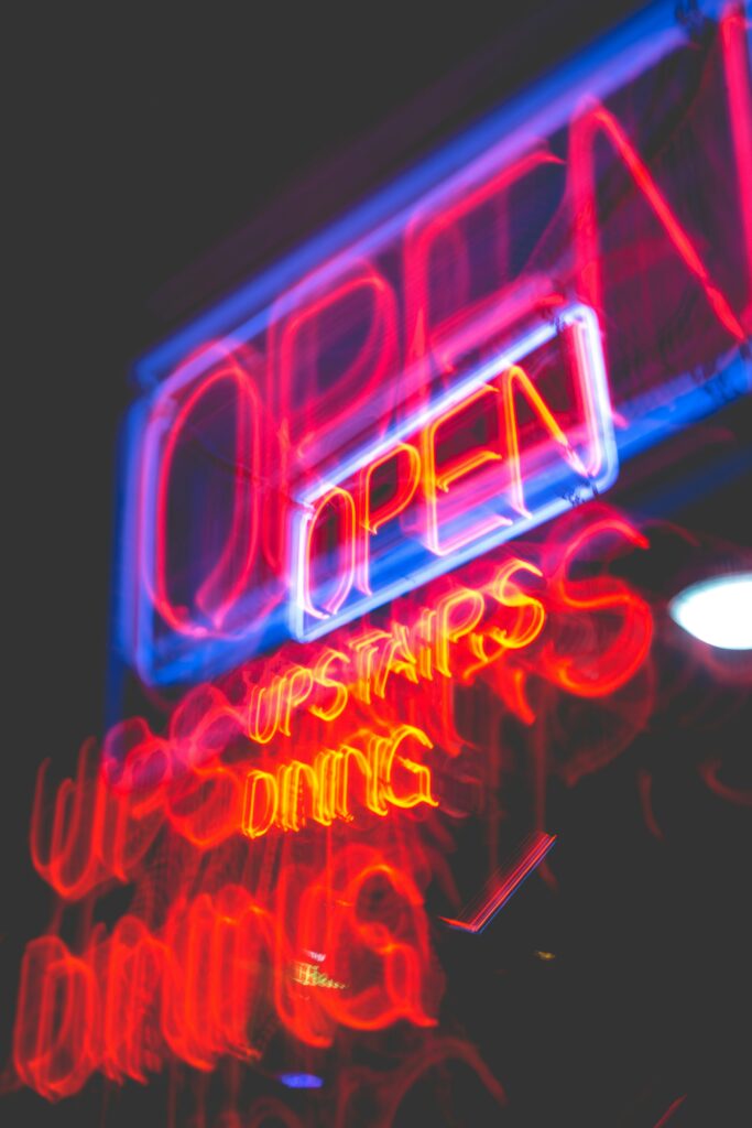 Neon sign with 'Open Upstairs Dining' message.