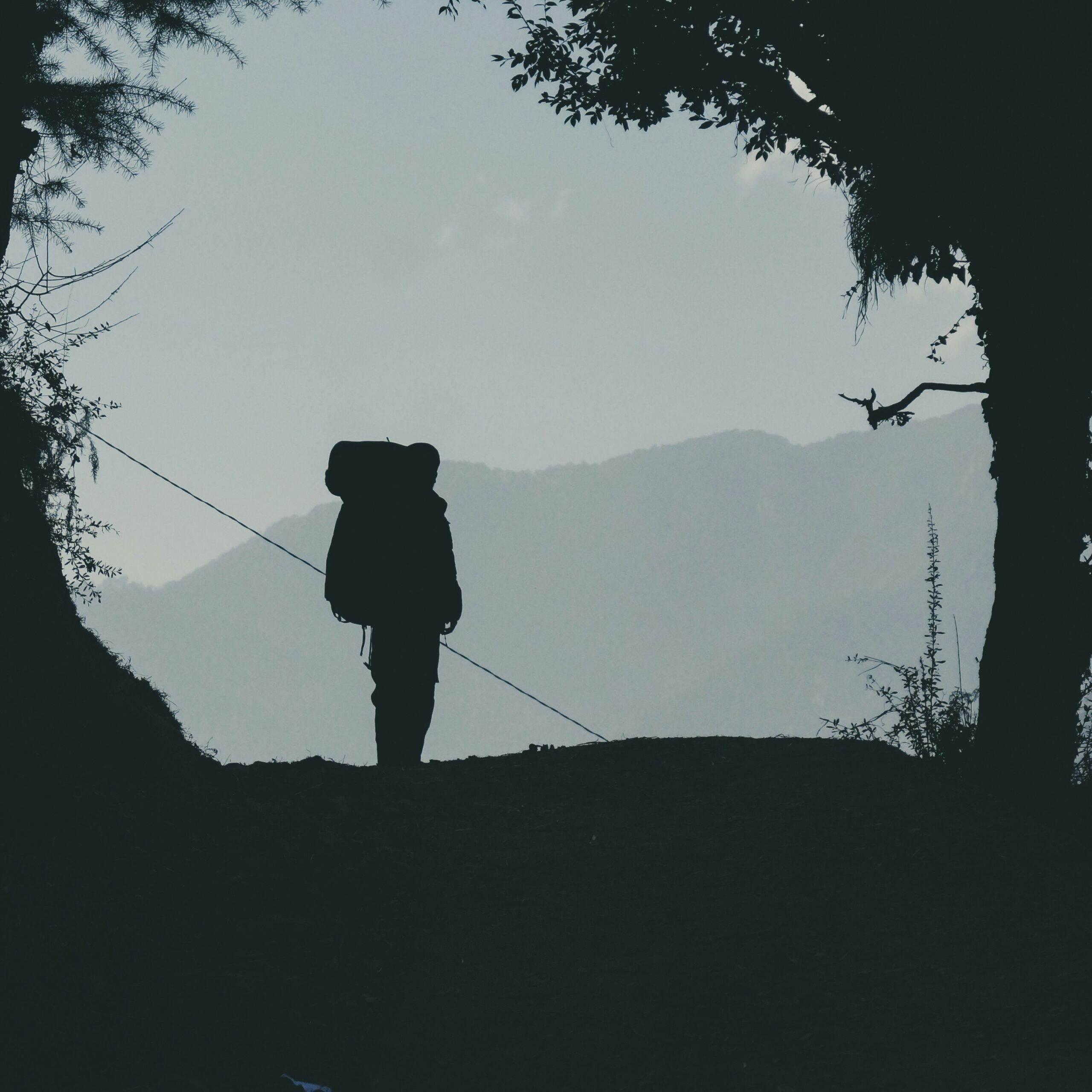 Silhouette of hiker on mountain trail.