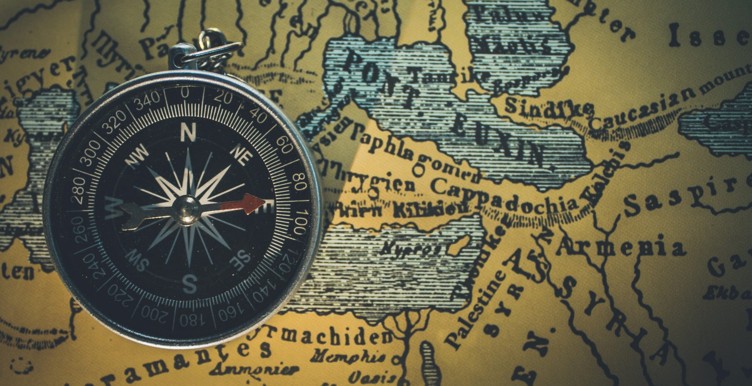 Compass on vintage world map background.